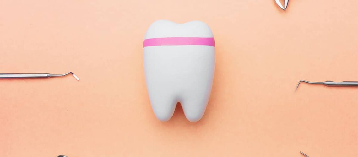 image of a tooth surrounded by dental tools, used in the process of how dentists evaluate enamel health