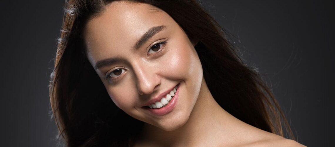 young woman posing in a model photoshoot and showing us how to smile for a photo