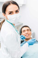 oral surgeon and her patient smile back at the camera