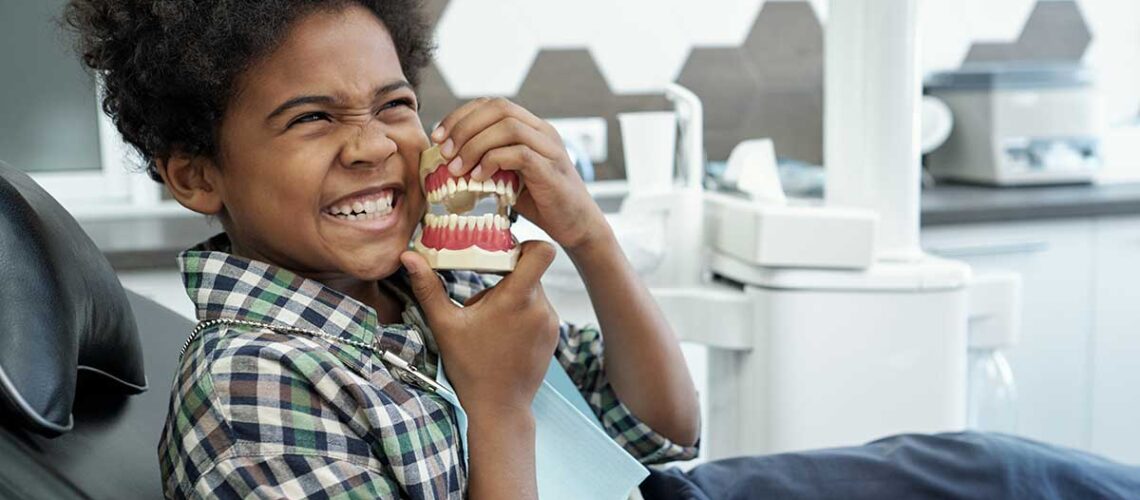 young child in the orthodontists chair getting checked out because his mom thinks she sees signs your child needs braces