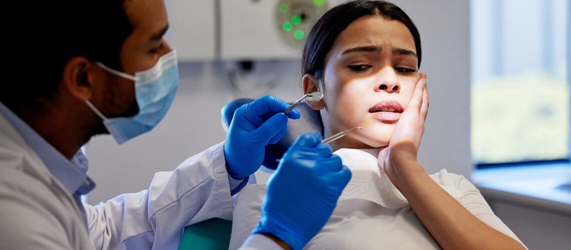 woman is in the dentist chair looking frightened and needs ways to cope with her dental anxiety