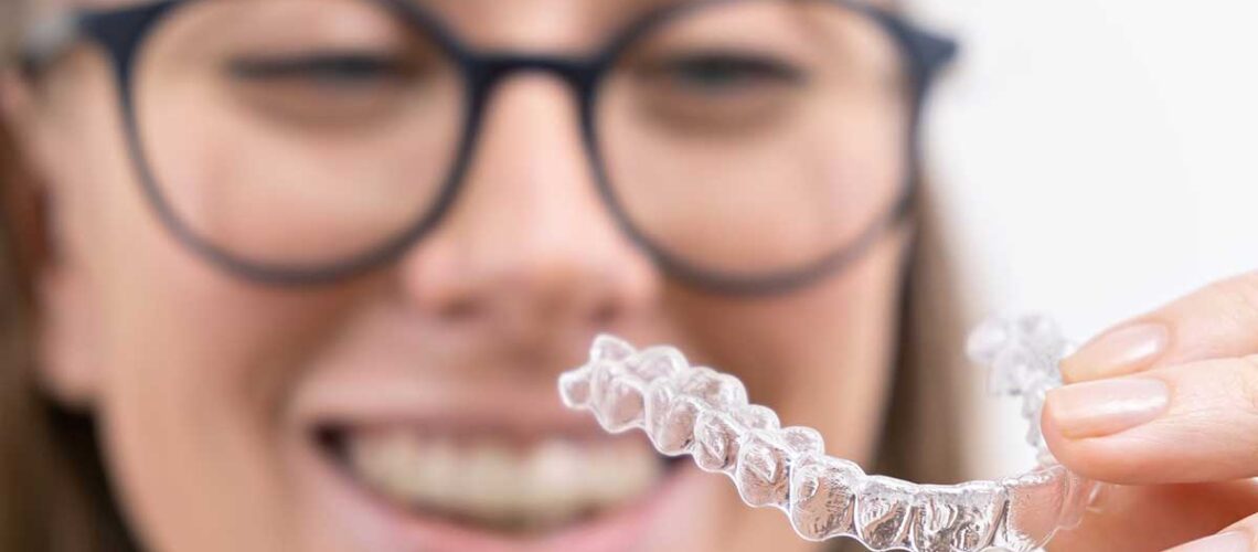 woman showing of her clear aligners after being asked what are clear aligners