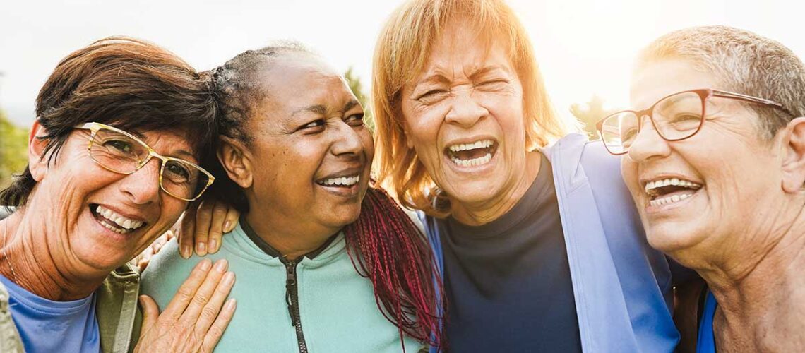 a group of diverse senior canadians laughing and emphasizing why the canadian dental care plan is so important